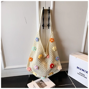 Détail d'un sac cabas au crochet fait main avec des fleurs 3D colorées en coton crème