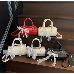 Vue détaillée des sacs Boston en cuir texturé en cinq couleurs avec nœuds en perles