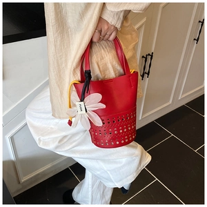 Détail motif géométrique découpé au laser sur sac seau rouge avec pochette jaune interne