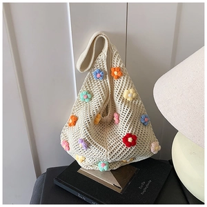 Gros plan d'un sac cabas en tricot crème avec broderies florales 3D colorées