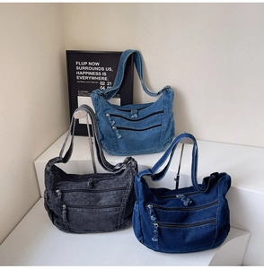 Close-up of vintage washed denim bags in black and blue with multiple zipper pockets