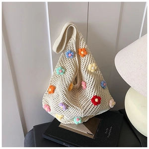 Détail d'un sac cabas en tricot crème orné de fleurs au crochet 3D colorées