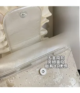 Detail of satin fabric with rhinestones, silver magnetic buckle, and ruffles on backpack