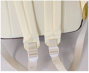 Detail of widened cushioned shoulder straps with white plastic adjustment buckles on the backpack