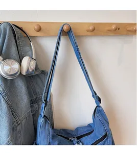 Close-up of adjustable smooth shoulder strap and denim material on blue crossbody bag