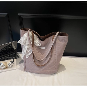Detail view of striped canvas tote with lace bow charm and Magic pocket label