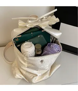 Detail of cream bucket backpack featuring pearl coating bow and large inner capacity