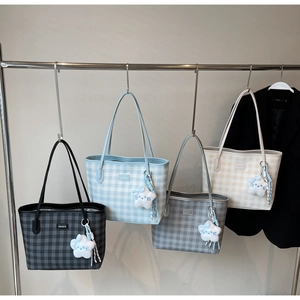 Detail view of plaid tote bags in black, blue, and beige with cute star plush charms