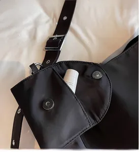 Detail view of the nylon bag featuring a practical magnetic flap pocket for cosmetics