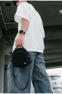 Détail d'un sac bandoulière en nylon noir imperméable avec bandoulière réglable