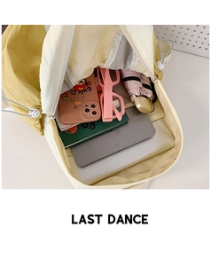 Top view showing large capacity interior of yellow nylon backpack with tablet and essentials