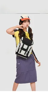 Detail of color-block nylon backpack with buckle closure on model for daily travel