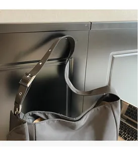 Detail of adjustable silver buckle on black nylon tote bag strap for shoulder use