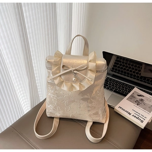 Close-up of beige ruffles and bow decoration with pearl pendant on the water bucket bag