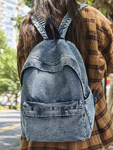 Vintage blue washed denim backpack for women with large capacity in an outdoor street setting