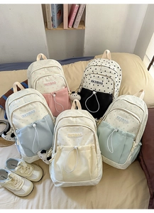 Detailed view of campus style backpacks with star prints and panda charms in five colors