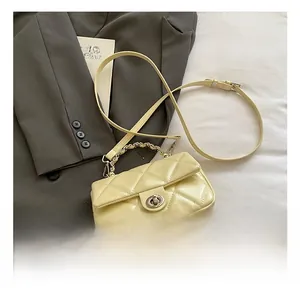 Macro shot of cream yellow quilted shoulder bag with metal chain and classic twist lock