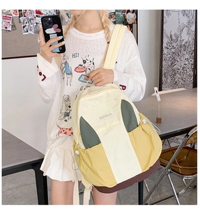 Detail of multi-color nylon backpack featuring yellow, green and brown patchwork design