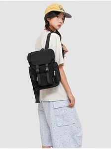 Detail view of black commuter backpack featuring flap cover with dual adjustable buckles
