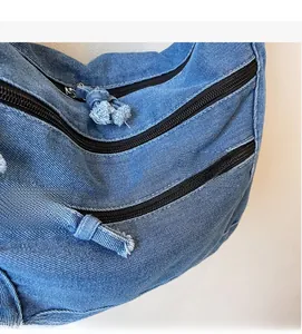 Close-up of blue denim shoulder bag showing fabric texture and zipper detail