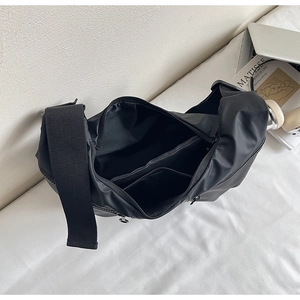 Detailed interior of black nylon crossbody bag showing large capacity and zipper pocket