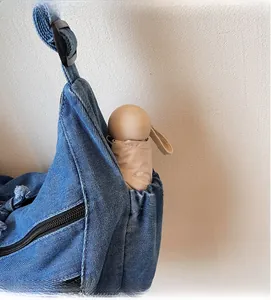 Detail of the denim tote side pocket showing storage capacity for a folding umbrella