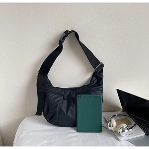 Detail of black nylon crossbody bag with digital devices showing large capacity storage