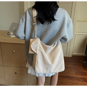 Spacious beige nylon tote bag with wide strap and pouch shown on a model