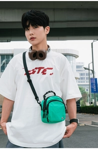 Photo de sac bandoulière en nylon vert imperméable avec sangle réglable et logo