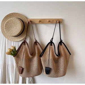 Detailed view of woven straw tote bag with leather straps for summer beach vacations