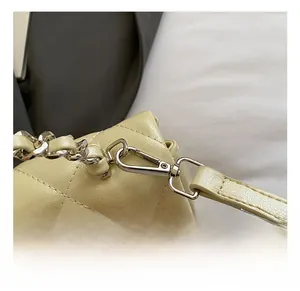 Detail of silver metal lobster clasp and quilted faux leather strap on handbag