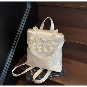 Close-up of cream white bucket bag featuring floral embroidery and elegant bow detail