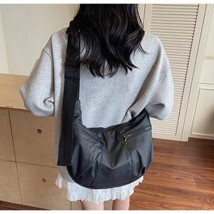 Detailed back view of a black waterproof nylon crossbody dumpling bag with wide straps