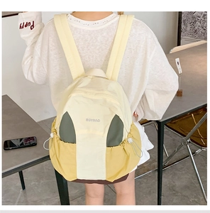 Detail of multi-color nylon backpack featuring drawstring side pockets and adjustable buckles