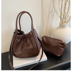 Deep brown pleated bucket bag set with matching inner pouch and gold lettering detail