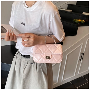 Detail of light pink quilted handbag with silver swivel lock and chunky chain handle
