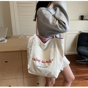Minimalist beige canvas tote bag with red embroidery and delicate lace ribbon detail