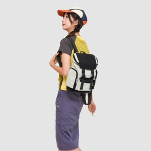 Detail of color-block backpack with black flaps and side pockets on a casual model