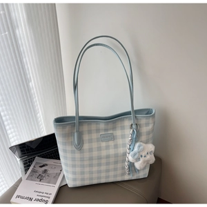 Detail of blue gingham canvas tote bag with leather logo and fluffy cloud charm accessory