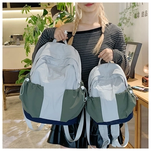 Detail shot of grey and green water-resistant nylon backpack with brand embroidery
