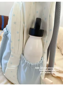Detail view of the backpack side pocket holding a water bottle with elastic closure