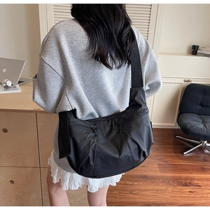 Detailed back view of a large black nylon crescent bag with wide crossbody shoulder strap