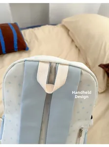 Detail of the top carry handle and wide shoulder straps on the star pattern backpack