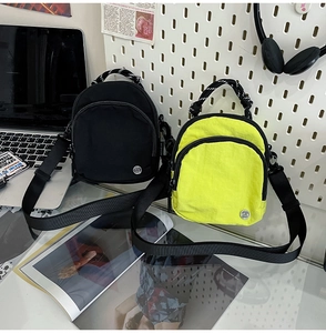 Détail du mini sac bandoulière en nylon imperméable avec double zip et logo S