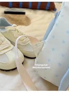 Detail of triangular reinforcement stitching on light blue star pattern backpack straps