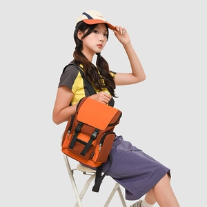 Detailed view of the multi-pocket canvas backpack with orange flap and buckle closure