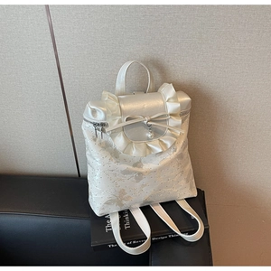 Detail of white bow bucket bag featuring floral embroidery and lace trim decorations