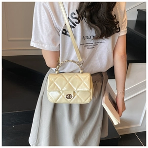 Detailed view of the creamy white quilted crossbody bag with silver chain handle and turn-lock