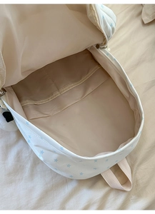 Internal view of a canvas backpack showing the spacious storage compartment and star pattern