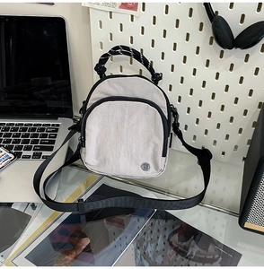 Détail d'un sac bandoulière en nylon imperméable avec bordure noire et sangle réglable